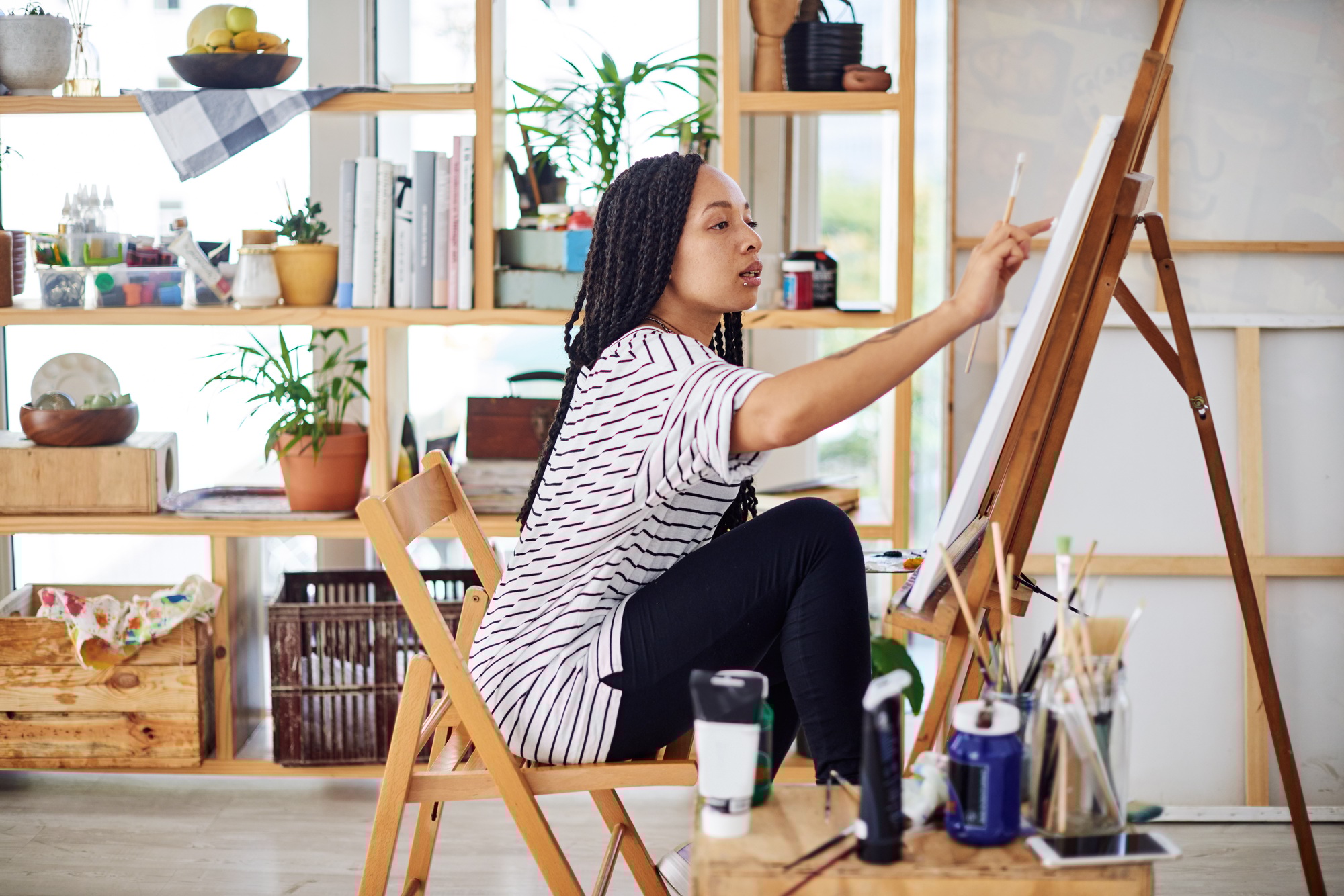 Shot of a beautiful young woman working on a painting in a art studio